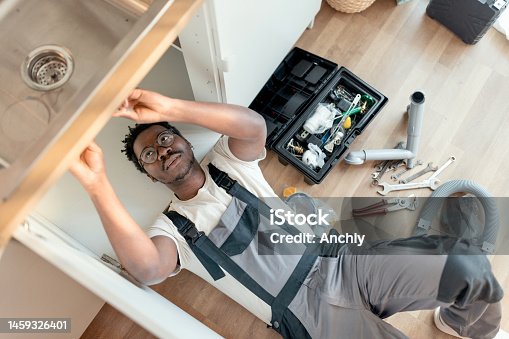 istock Plumber working on pipes under sink 1459326401