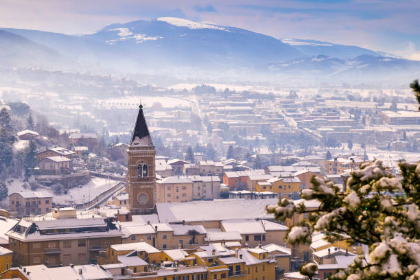 A winter townscape with snowy rooftops in a medieval village in Umbria central Italy A beautiful winter townscape with snowy rooftops in the medieval village of Gualdo Tadino in Umbria, central Italy. The Umbria region, considered the green lung of Italy for its wooded mountains, is characterized by a perfect integration between nature and the presence of man, in a context of environmental sustainability and healthy life. In addition to its immense artistic and historical heritage, Umbria is famous for its food and wine production and for the high quality of the olive oil produced in these lands. Image in high definition format. gualdo tadino stock pictures, royalty-free photos & images