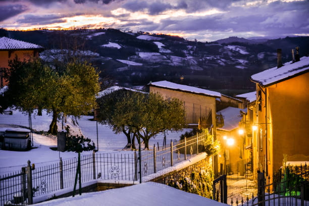 A suggestive winter atmosphere at twilight among the snowy alleys of a medieval village in Umbria in Italy A winter atmosphere in the evening in the snowy stone alleys of the medieval village of Gualdo Tadino in Umbria, central Italy. The Umbria region, considered the green lung of Italy for its wooded mountains, is characterized by a perfect integration between nature and the presence of man, in a context of environmental sustainability and healthy life. In addition to its immense artistic and historical heritage, Umbria is famous for its food and wine production and for the high quality of the olive oil produced in these lands. Image in high definition format. gualdo tadino stock pictures, royalty-free photos & images