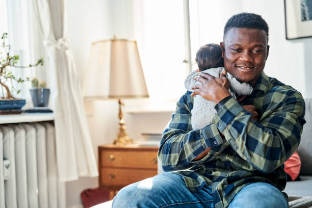 istock Smiling father embracing son at home 1459326669