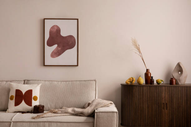 istock Interior design of living room interior with mock up poster frame, modern sofa, wooden commode, plaid, pillow, vase with dried flowers, pumpkin and personal accessories. Home decor. Template. 1459327042