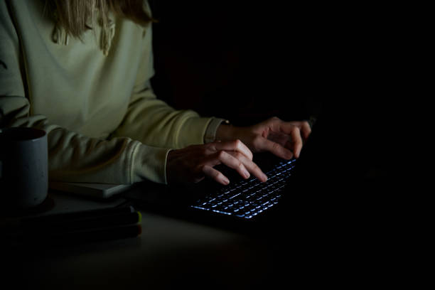istock Anonymous woman working on laptop at night 1459328581