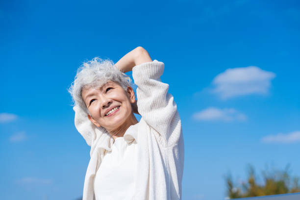 Senior woman stretching under the blue sky