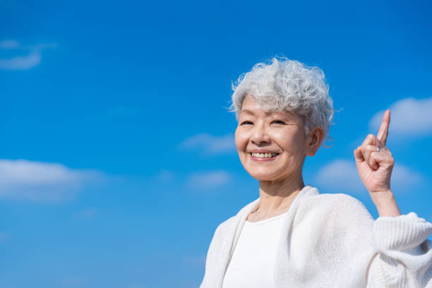 istock Senior woman pointing out a recommendation under the blue sky 1459331078