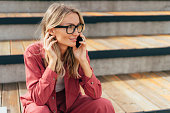 Young business woman talking on a mobile phone outside.