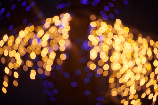 Yellow lights bokeh from christmas holiday garlands, blurred festive background, abstract outdoor lights with boke. Bright yellow bokeh lights with beautiful shiny on dark night background