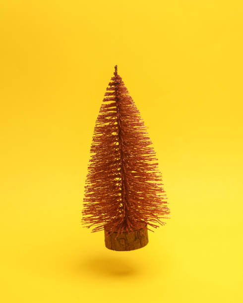 istock Miniature Christmas tree floating in the air on a yellow background with a shadow. Creative idea. Minimal concept. Levitating objects 1459334986