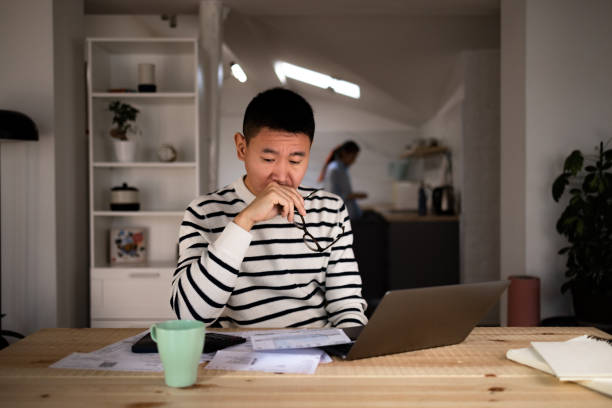 istock Displeased Chinese man going through his home finances. 1459335484