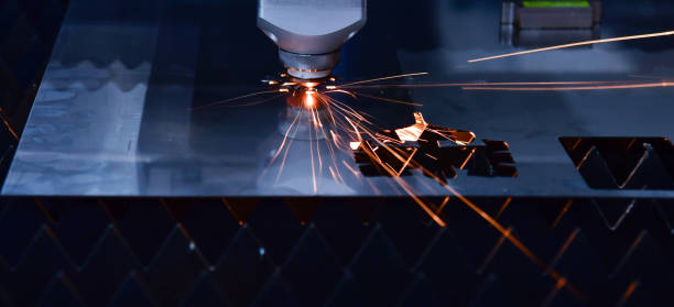 Industrial laser cut machine while cutting the sheet metal with the sparking light stock photo