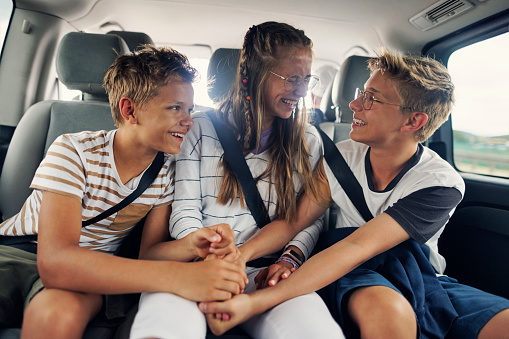 Three teenage kids enjoying road trip in car. Kids are aged 13 and 16. They are playing rock paper scissors.
Canon R5