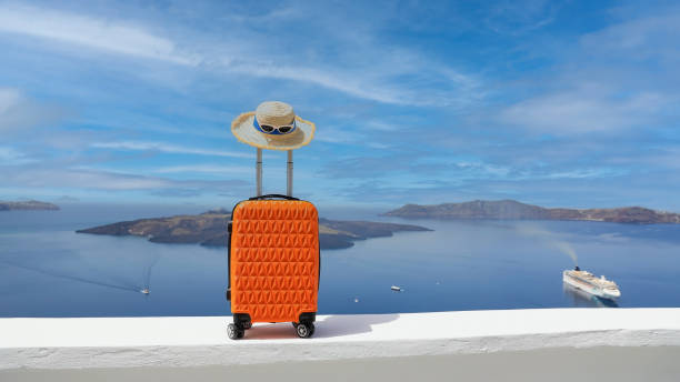 pomarańczowy bagaż z kapeluszem i widokiem krajobrazu miasta oia na wyspie santorini w grecji, grecki krajobraz jako błękitne niebo - hat oia europe vacations zdjęcia i obrazy z banku zdjęć