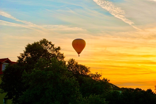 A red balloon at sunset. A fiery sunset and a balloon. A balloon in Upper Bavaria flies at sunset.