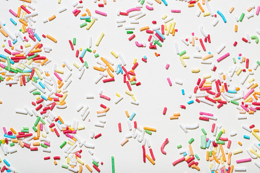 Photo of confectionery sprinkles on a light background. Texture, pattern.