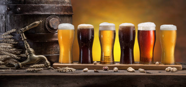 istock Collection of different chilled beer on wooden table. Cellar interior. 1459345115