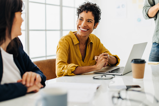 Business woman talking to her colleague during a meeting in a boardroom. Female business professionals having a discussion. Creative business people planning a project in an office.