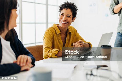 istock Business woman talking to her colleague during a meeting in a boardroom 1459345582