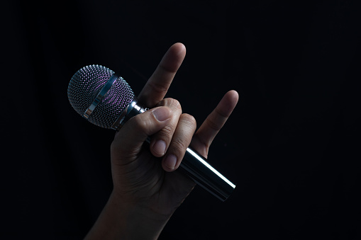 Male hand microphone on stage at night singer concept, speech, performance