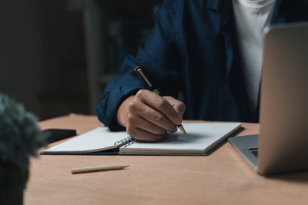 istock Businessperson reading and writing on book.education studying knowledge development and cognition learning concept. 1459360433