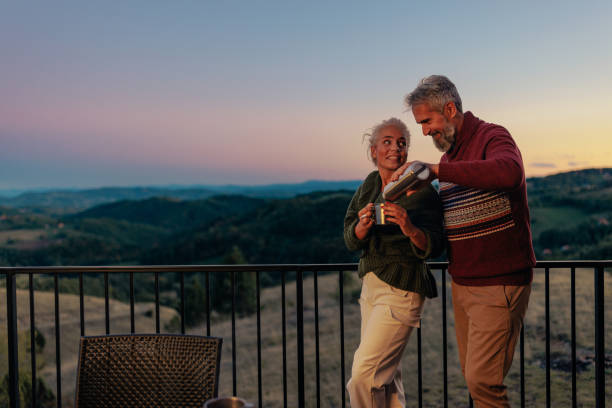 istock Senior couple drink tea at mountain house. 1459360513