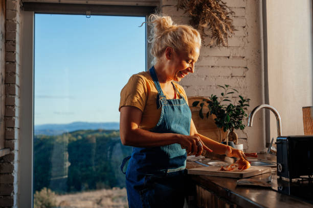 Woman making salad in kitchen.