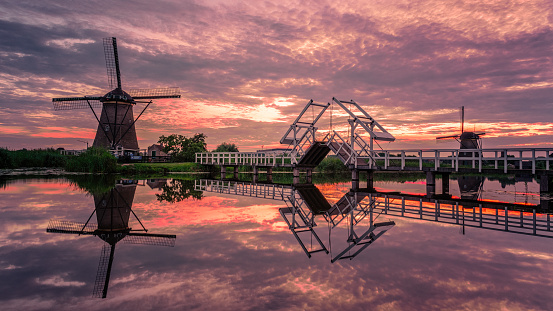 windmill village Kinderdijk in the Netherlands during sunset, wooden historical mill at sunset