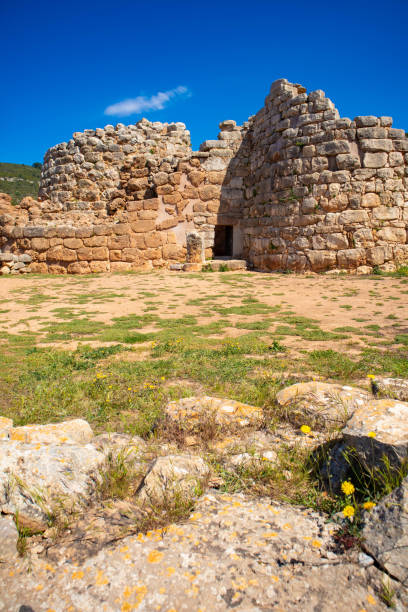 Romanesque church of Santa Sabina on Silanus, Sardinia, Italy. Panorama landscape of the church and the prehistoric tower, also known as Nuraghe. Nuraghe is the typical prehistoric sardinian building of the megalithic age, dated back before 1000 BC.