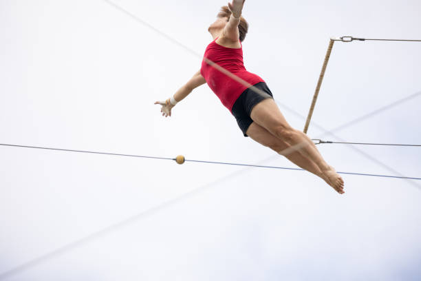 istock Professional trapeze artist flying in the sky 1459363812