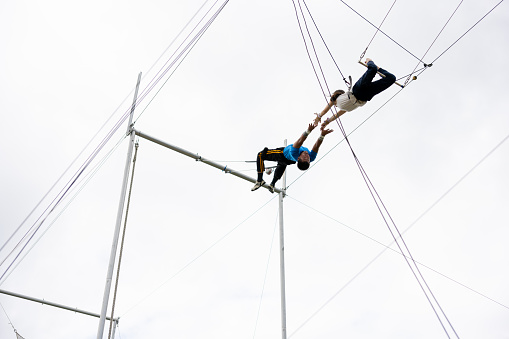 Trapeze artist catching the partner in the sky