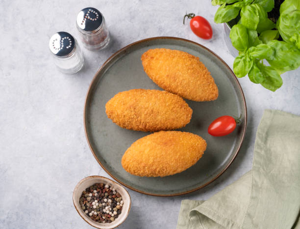 istock Chicken Kiev cutlets on a plate with fresh tomatoes, herbs and spices. 1459364715