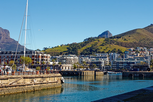 Entrance to small craft harbour in Cape Town Waterfront with apartments and Signal Hill in background