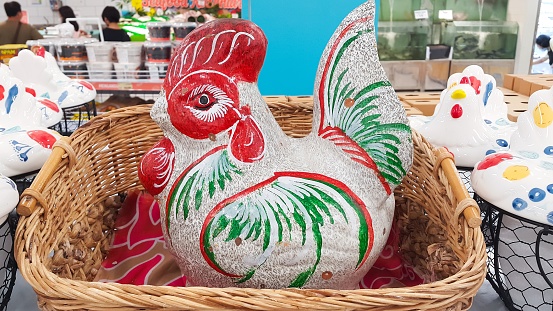 Chicken piggy bank in a rattan basket on a shelf in a supermarket. For saving money.