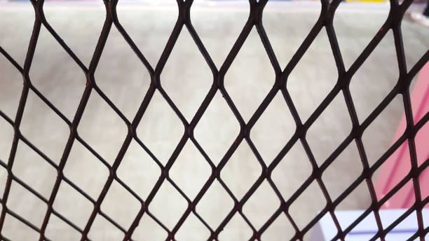 istock Wire mesh fence with blurred background of concrete floor 1459365438
