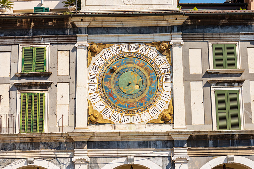 Brescia downtown. Close-up of the clock and bell tower in Renaissance style, 1540-1550, in Loggia town square (Piazza della Loggia). Lombardy, Italy, Europe. Astronomical clock with the constellations of the zodiac.