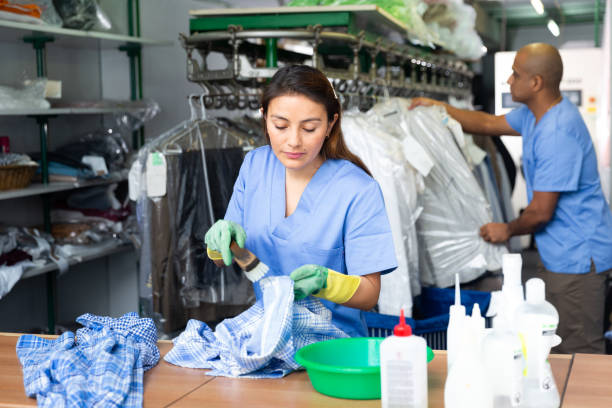 istock Focused woman drycleaner removing spots and stains 1459369370