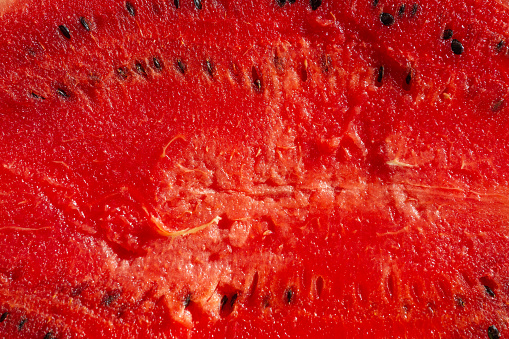 Red pulp of ripe watermelon texture. Background red pulp of ripe watermelon with pits.