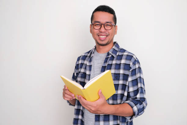 istock Adult Asian man smiling confident when holding a book 1459370555