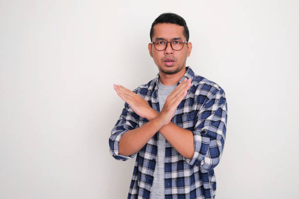 istock Adult Asian man looking camera with serious expression with his hand making block gesture 1459370560