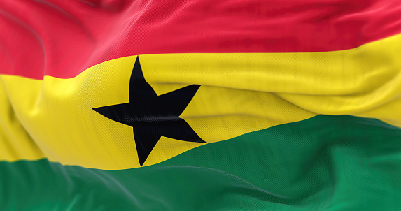 Close-up view of the national flag of Ghana waving. Selective focus. Fluttering fabric. Realistic 3d illustration. Red, yellow, green stripes, black star in center.