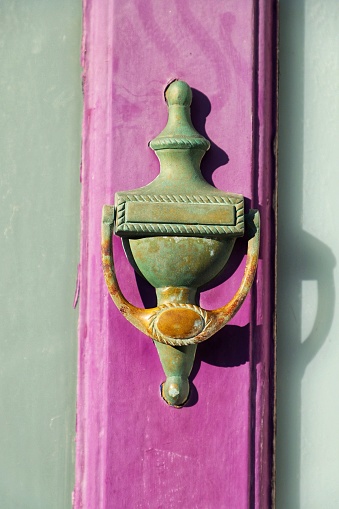 characteristic English doorknob, on a purple door in the city of Brighton, England