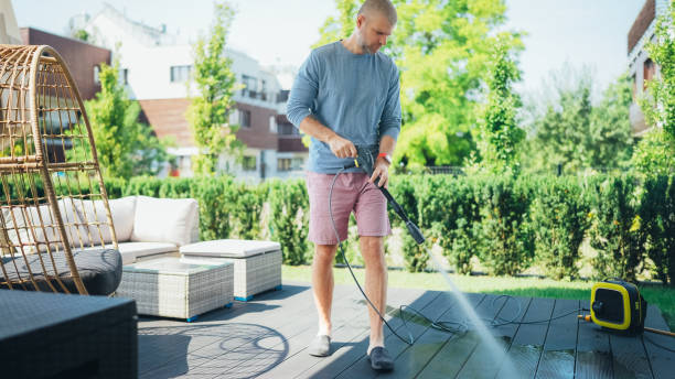 Man cleaning his veranda with high pressure washer stock photo