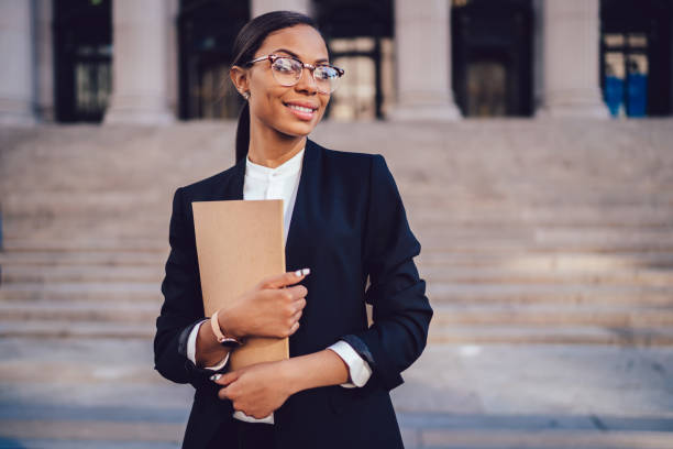 istock Joyful black specialist with documents looking away in street looking away 1459381940