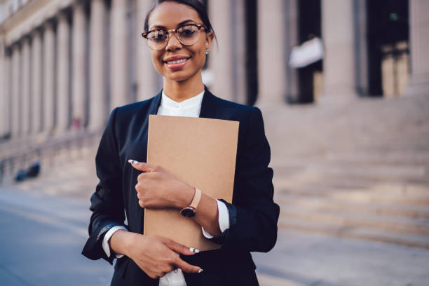istock Intelligent black specialist holding folder with documents and looking at camera 1459381952