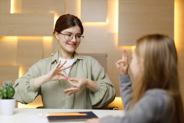 istock Learning sign language, cheerful woman communicates with a child. School for the deaf or dumb. 1459383556
