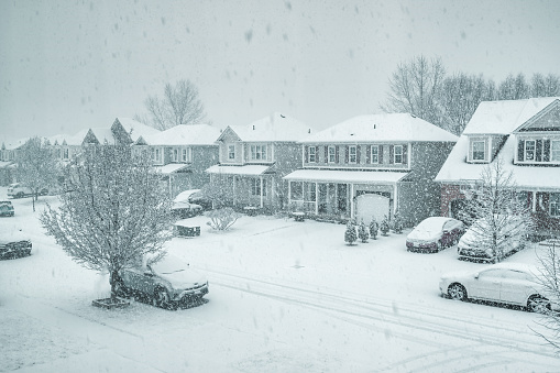 Row of detached houses in a residential district in Brantford, Ontario, Canada during a winter snow storm.