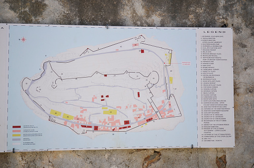 Spinalonga, Crete, Greece - October 10, 2022: Map and legend of the old Venetian Fortress Spinalonga, until 1957 used as a leper station, now a popular tourist destination