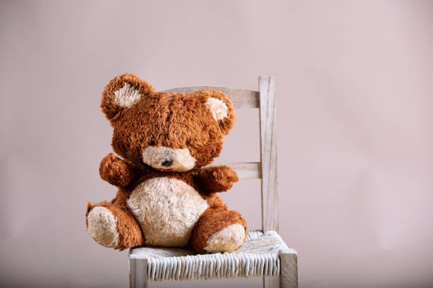 istock old teddybear on wooden chair 1459384195