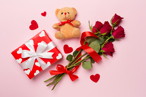 Valentines day gifts with red roses on color background, top view