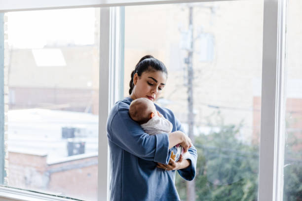 istock Nanny stands and holds onto young child 1459386032