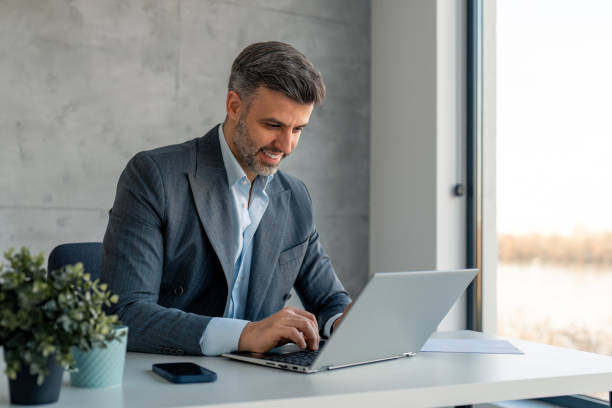 istock Busy handsome male manager using laptop doing market research at workplace 1459388325
