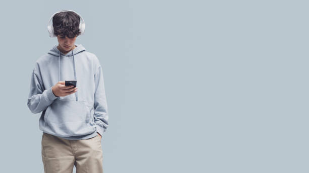 istock Teenager standing and using a smartphone 1459388604